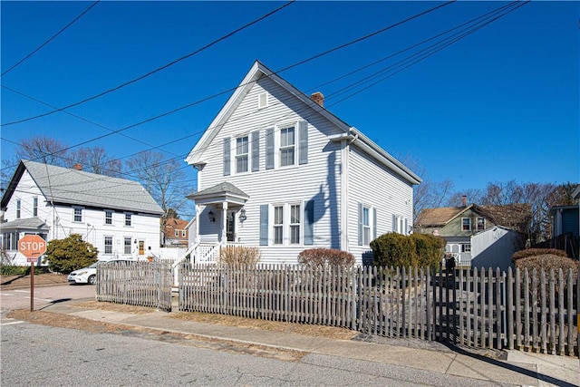 view of front facade with a fenced front yard and a chimney