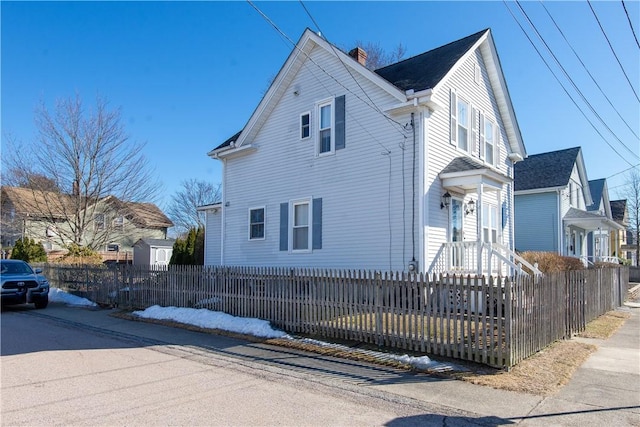 view of home's exterior with a fenced front yard and a chimney