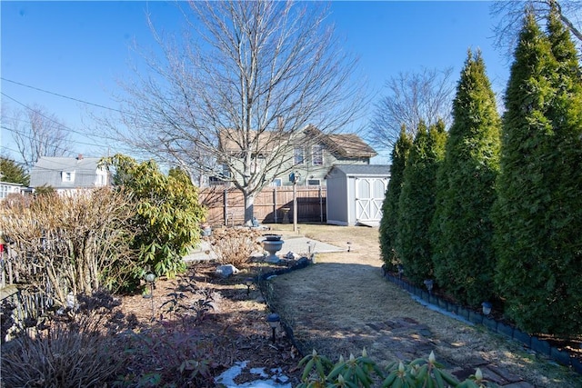 view of yard featuring a shed, an outdoor structure, and a fenced backyard