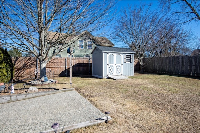 view of yard with an outbuilding, a storage unit, and a fenced backyard