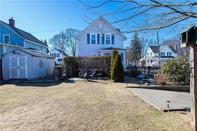 view of yard featuring a shed, fence, and an outbuilding