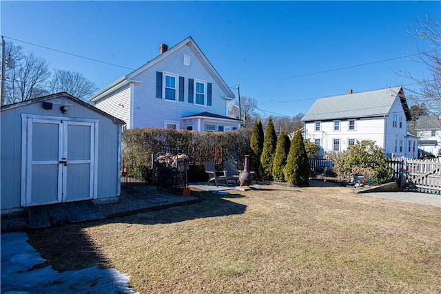 exterior space featuring an outbuilding, a patio area, fence, and a shed