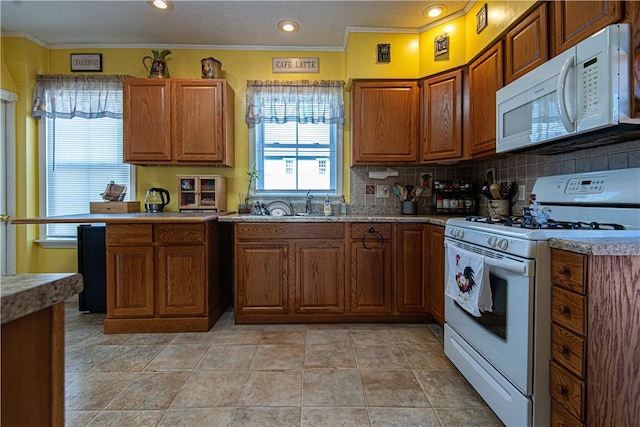 kitchen featuring white appliances, backsplash, and brown cabinets