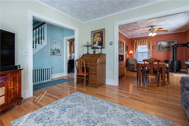 living room with ceiling fan, ornamental molding, stairway, and wood finished floors