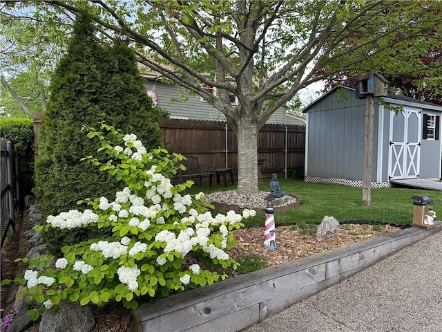 view of yard featuring an outbuilding, a fenced backyard, and a storage unit