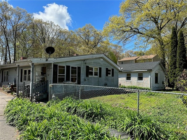 view of front facade featuring a front yard and fence