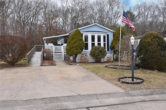 view of front facade featuring a porch, concrete driveway, and a front lawn