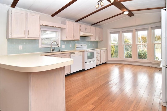 kitchen featuring white appliances, lofted ceiling with beams, a peninsula, light countertops, and under cabinet range hood