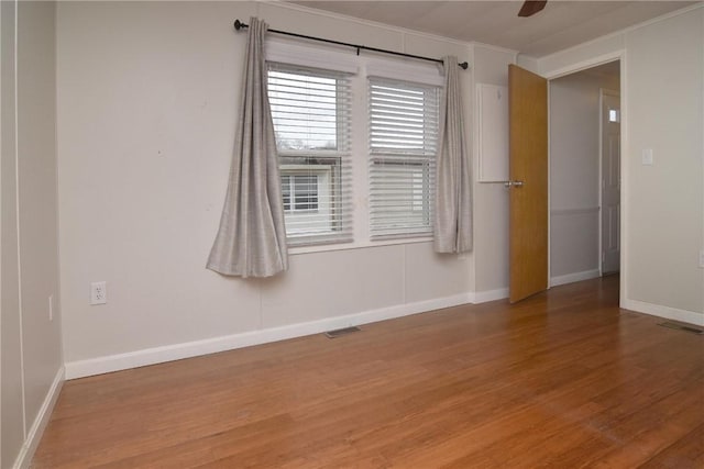 spare room with wood finished floors and visible vents