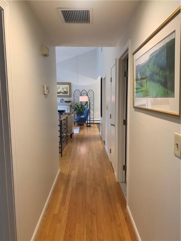 corridor with wood finished floors, visible vents, and baseboards