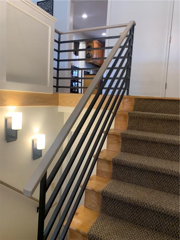 staircase with a high ceiling and wood finished floors