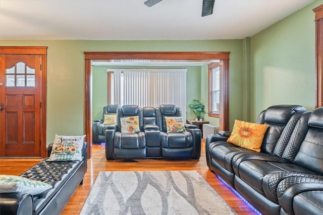 living room with a ceiling fan and light wood finished floors