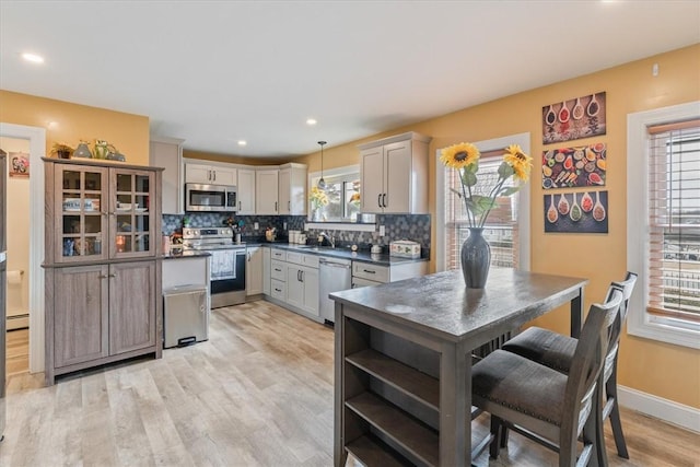 kitchen with dark countertops, tasteful backsplash, appliances with stainless steel finishes, and a sink