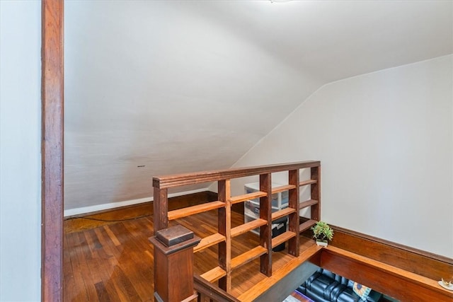 stairs with vaulted ceiling, hardwood / wood-style floors, and baseboards