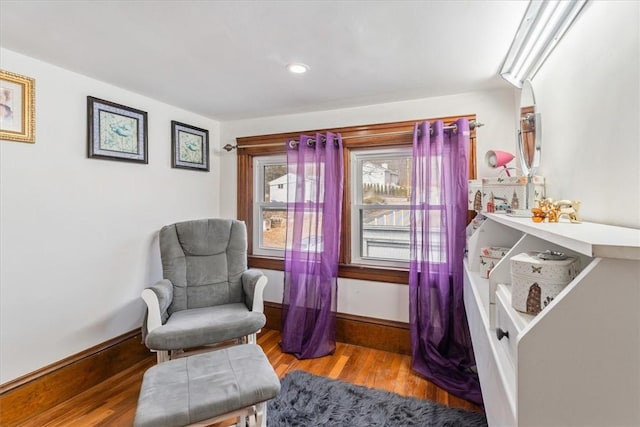 living area with baseboards and wood finished floors