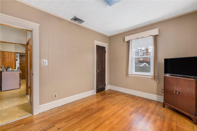 interior space featuring baseboards, visible vents, and hardwood / wood-style floors