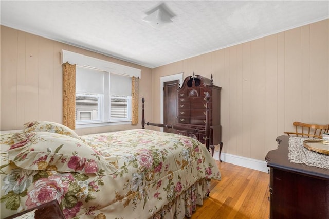 bedroom with baseboards and wood finished floors