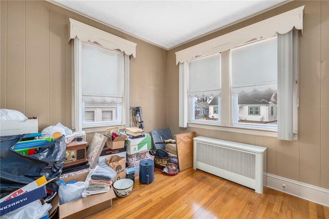 misc room with radiator, a decorative wall, and hardwood / wood-style floors