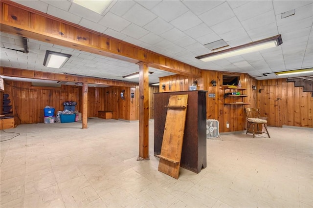 finished below grade area featuring wooden walls and tile patterned floors