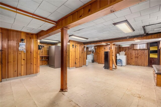 finished basement with wooden walls and tile patterned floors