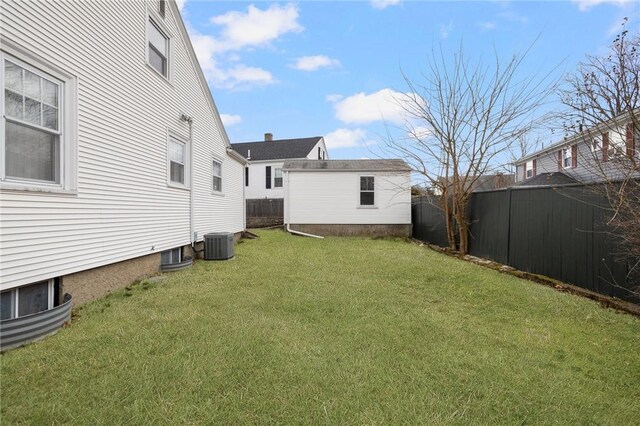 view of yard featuring an outdoor structure, a fenced backyard, and central air condition unit