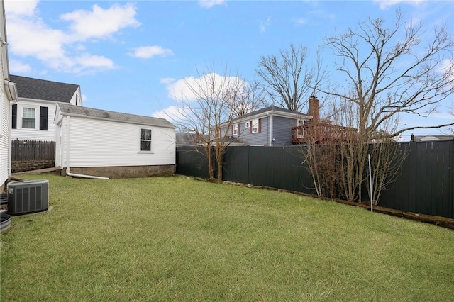 view of yard with an outbuilding, a fenced backyard, and central air condition unit