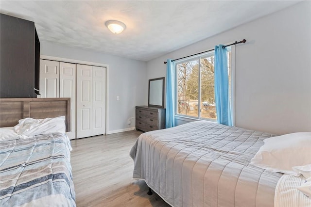 bedroom with a closet, wood finished floors, and baseboards