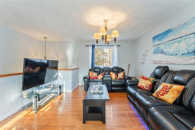 living room with wood-type flooring, baseboards, and a notable chandelier