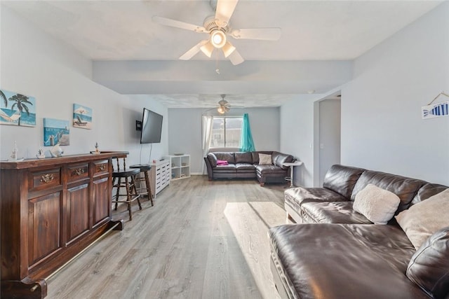 living area with light wood-style floors and a ceiling fan