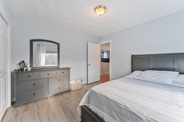 bedroom with light wood-style flooring and baseboards