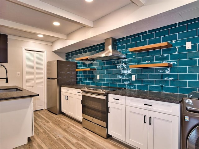 kitchen featuring open shelves, washer / dryer, wall chimney exhaust hood, and stainless steel appliances