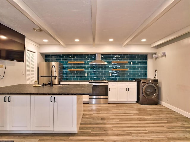 kitchen with beam ceiling, washer / clothes dryer, light wood-style flooring, appliances with stainless steel finishes, and wall chimney range hood