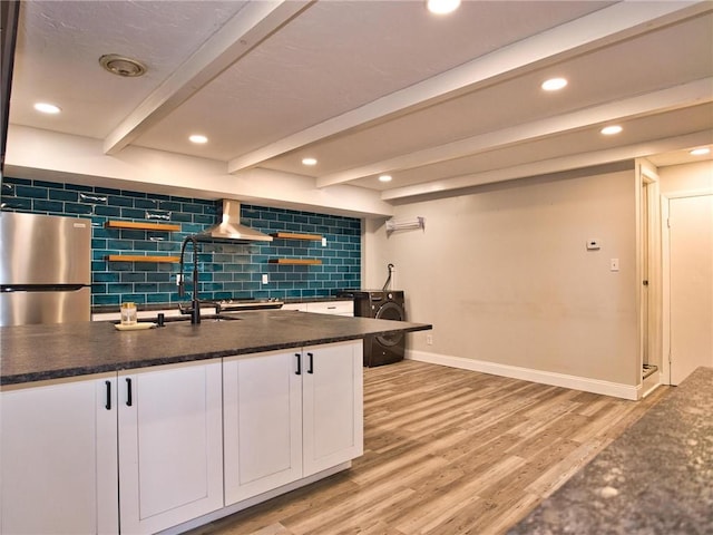 kitchen with white cabinets, beamed ceiling, freestanding refrigerator, light wood-type flooring, and backsplash