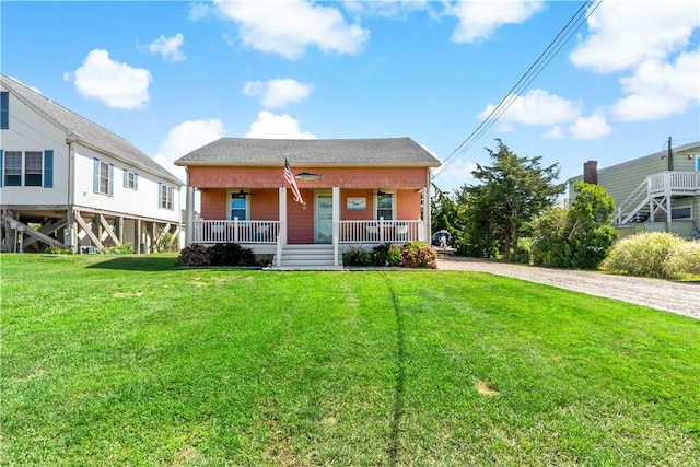 view of front facade featuring driveway, covered porch, and a front lawn