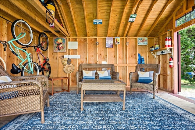 sitting room with lofted ceiling and wooden walls