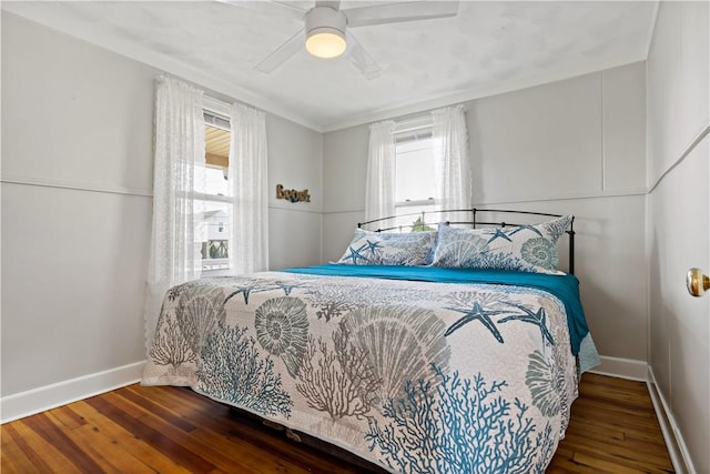 bedroom with multiple windows, baseboards, and hardwood / wood-style floors