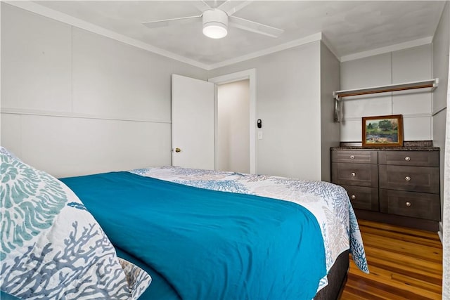 bedroom featuring a ceiling fan, wood finished floors, and ornamental molding