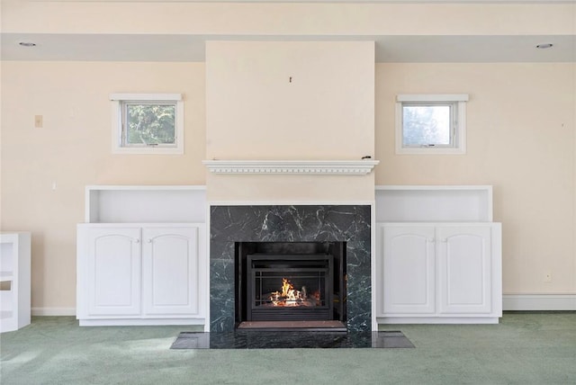 interior details with a premium fireplace, baseboards, and carpet flooring