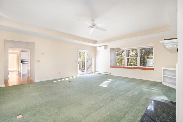 unfurnished living room featuring carpet, baseboards, baseboard heating, and a raised ceiling