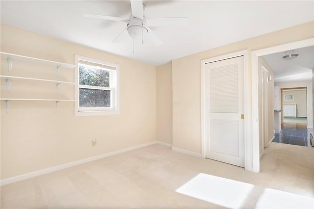 unfurnished bedroom with carpet floors, a closet, ceiling fan, and baseboards