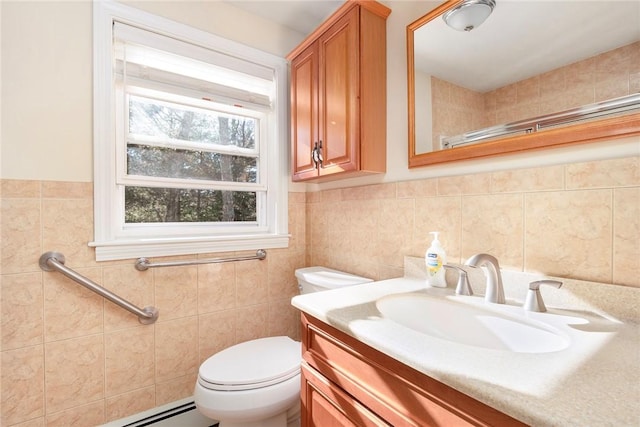 bathroom with tile walls, vanity, toilet, and baseboard heating