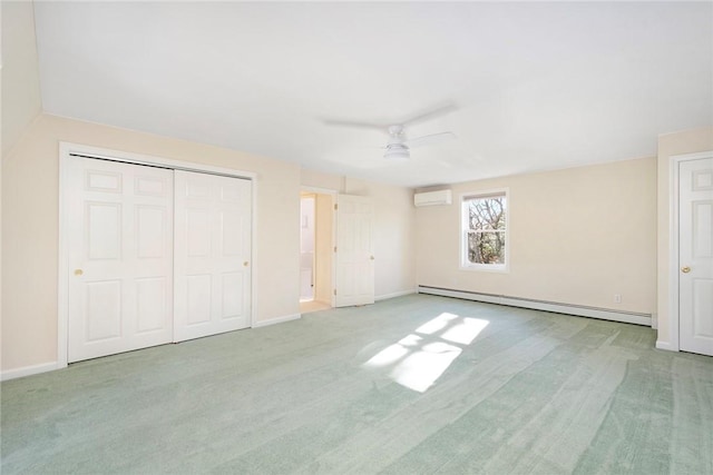 unfurnished bedroom with a baseboard heating unit, a wall mounted AC, carpet flooring, and baseboards