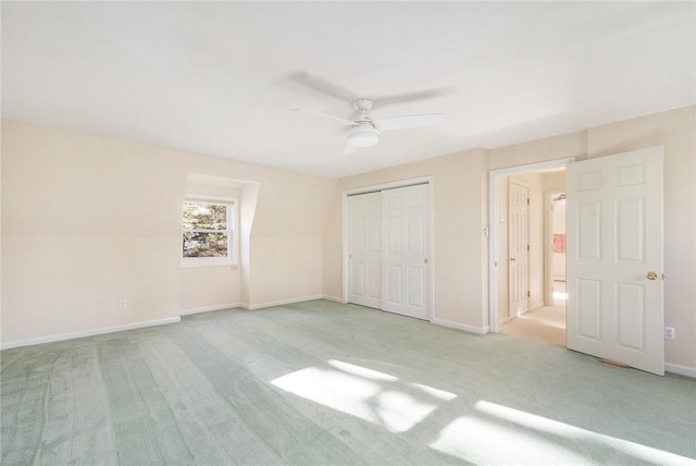 unfurnished bedroom with light carpet, ceiling fan, baseboards, and a closet