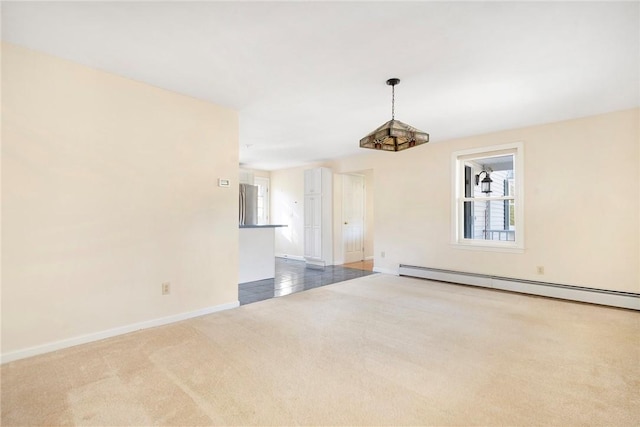 empty room featuring carpet floors, a baseboard radiator, and baseboards