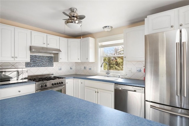 kitchen with ceiling fan, under cabinet range hood, stainless steel appliances, a sink, and white cabinets