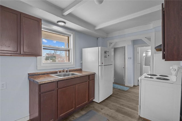 kitchen featuring white appliances, dark countertops, wood finished floors, a sink, and beam ceiling