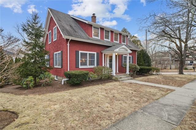 view of front of house with roof with shingles and a chimney