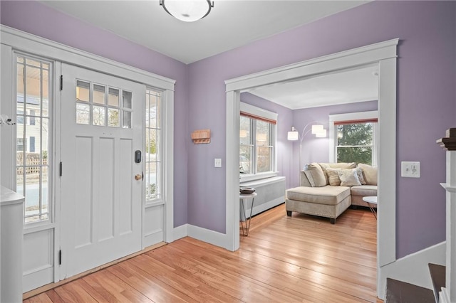 foyer entrance with baseboards and light wood-style floors