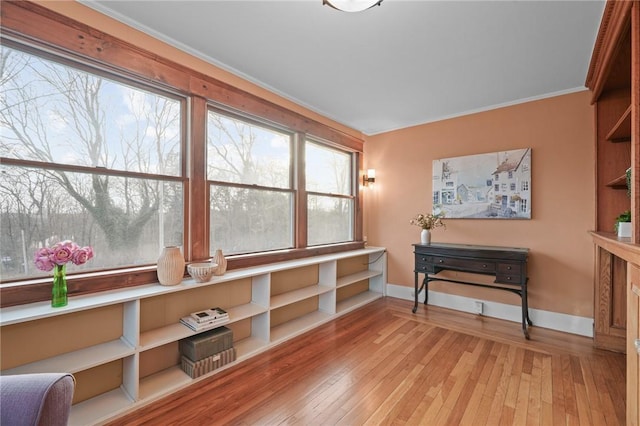 sitting room with crown molding, baseboards, and hardwood / wood-style flooring