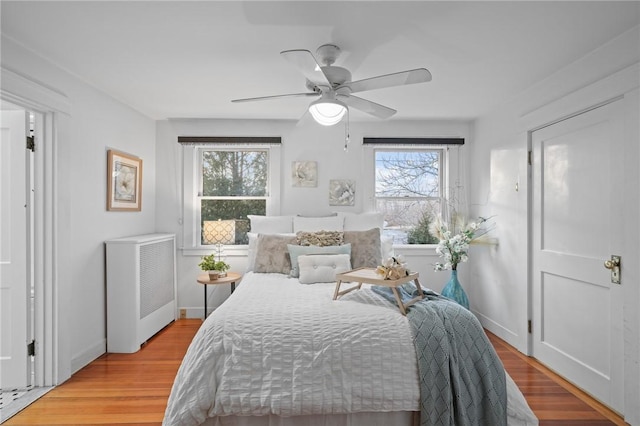 bedroom featuring light wood-type flooring, ceiling fan, and baseboards